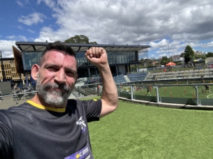 Christian Paesano from The Body Project smiling after finishing the Step Out for Cancer Run, celebrating achievement and community support for cancer awareness.