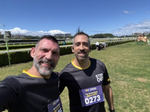 Christian Paesano and friend Roy at Randwick Racecourse after completing the Step Out for Cancer Run, celebrating the finish and supporting cancer awareness.