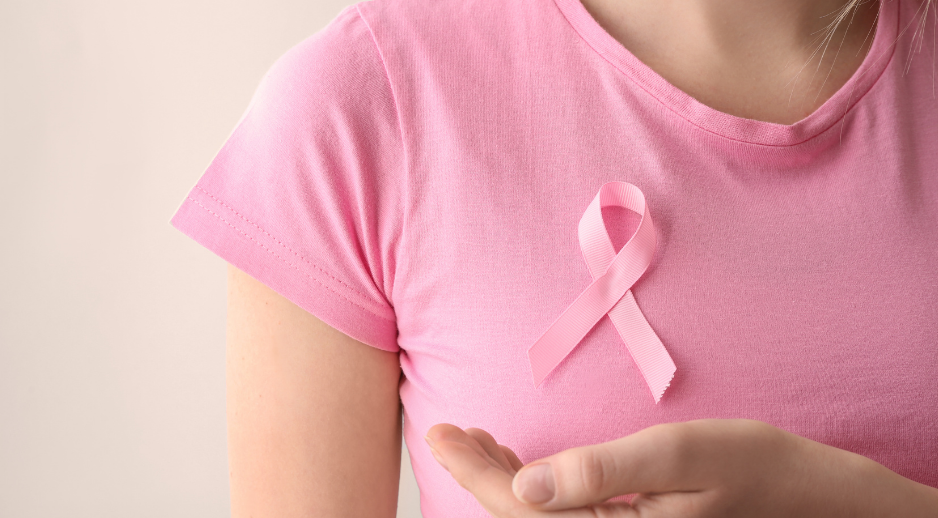 "Person wearing a pink breast cancer awareness ribbon representing recovery and rehabilitation after breast cancer treatment.